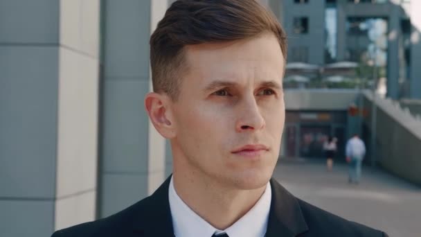Portrait of attractive business man in business suit in looking into camera in the city on downtown district. Confident male businessman standing outdoor near office building. - Footage, Video