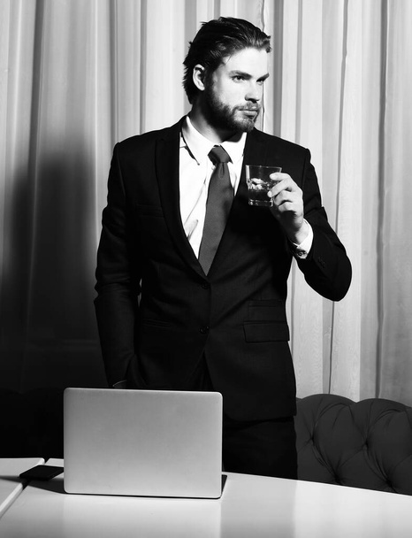 bearded man, businessman with glass of whiskey, cell phone, laptop - Valokuva, kuva