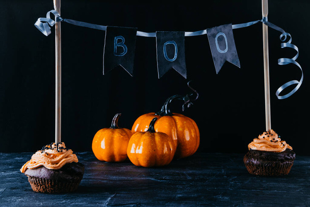  Halloween sweets, chocolate cupcakes and pumpkin on a black background. Copy space - Fotó, kép