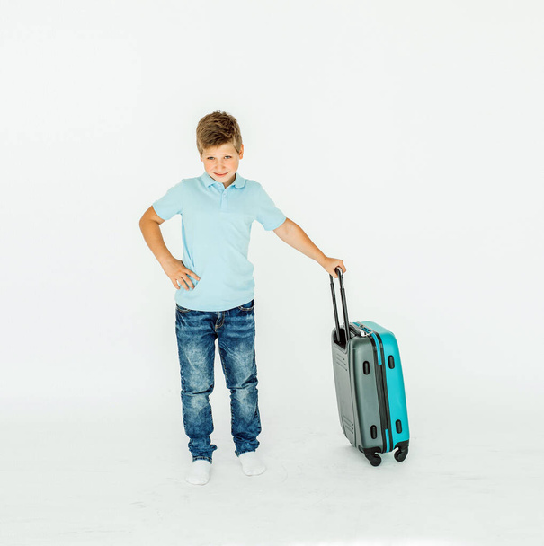 Мальчик-путешественник с чемоданом. Изолированный на белом фоне - Фото, изображение
