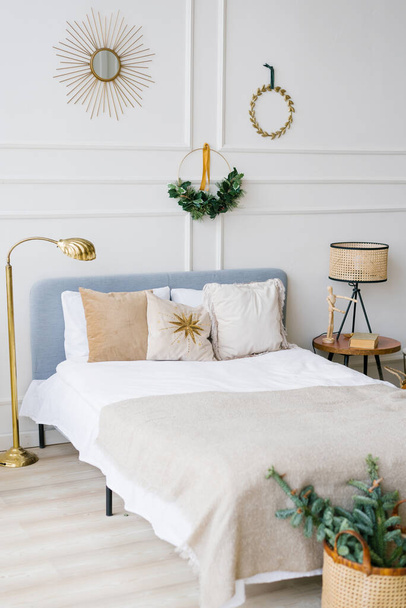 Cozy bedroom with bed and christmas garland lights at home  - Photo, Image