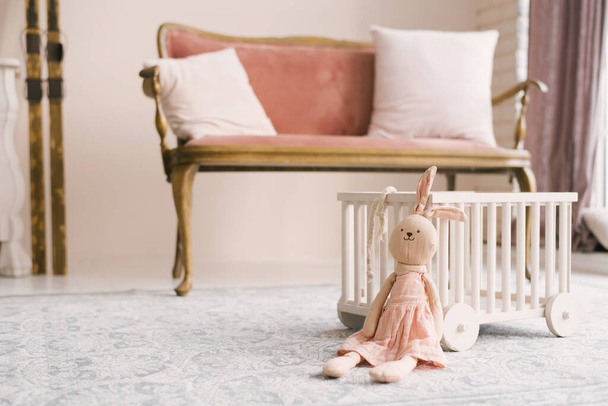 Zacht zelfgemaakt speelgoed Bunny in een roze jurk in de kinderkamer - Foto, afbeelding