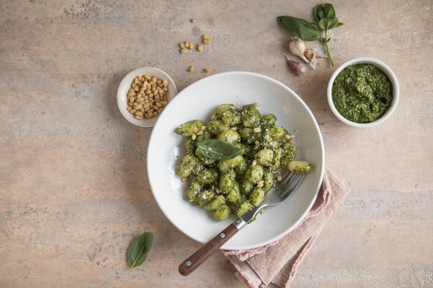 Italian food: homemade gnocchi with pesto sauce Parmesan and basil on concrete  table - Foto, Bild