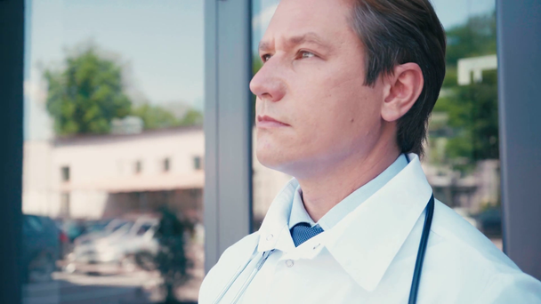 szelektív fókusz orvos nyitó ajtó és leveszi orvosi maszk kívül - Felvétel, videó