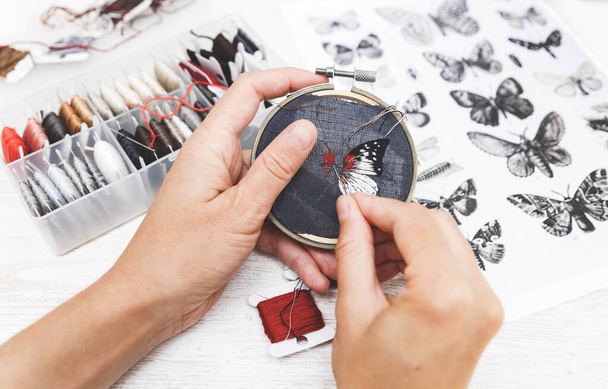 Woman embroider a butterfly. Process of making handmade embroidery. Hobby. Sewing tools. Remote home work. - Φωτογραφία, εικόνα
