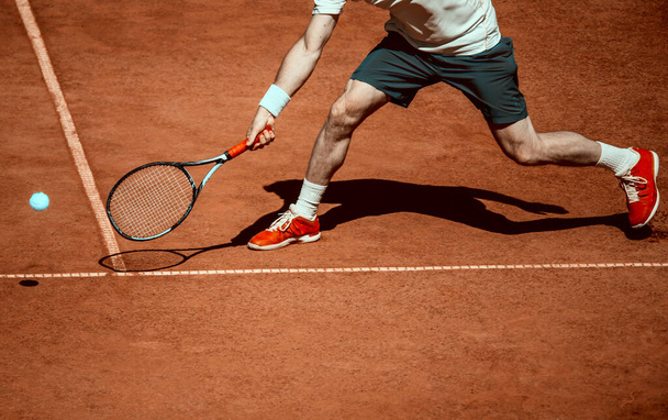 Mężczyzna tenisista w akcji na korcie w słoneczny dzień. Vintage filtr kolorów - Zdjęcie, obraz