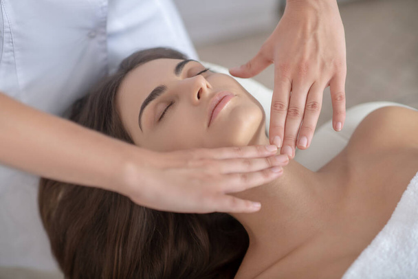 Professional massage therapist massaging face of a woman - Photo, image