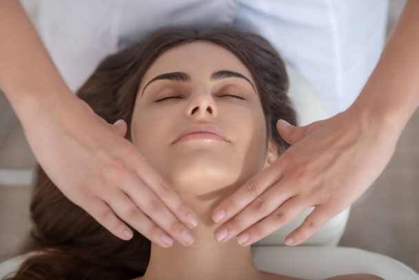 Professional massage therapist putting hands on customers neck - Zdjęcie, obraz