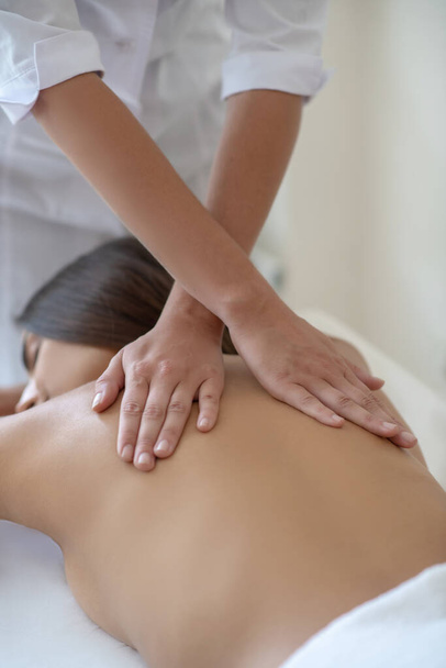 Young woman lying down and having back massage - Photo, Image