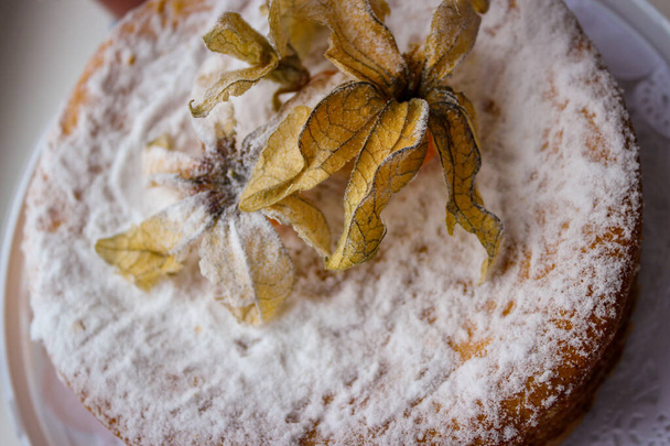 Ongelooflijk Heerlijk zelfgebakken taart. De top is versierd met eetbare Physalis Fruit. - Foto, afbeelding