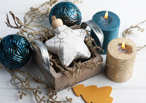 Blue and golden aroma candles and Christmas toys on wooden rustic background. Winter set with copy space - Photo, Image