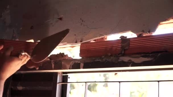 Uomo che installa una finestra in una vecchia casa utilizzando il metodo grezzo in Brasile - Filmati, video