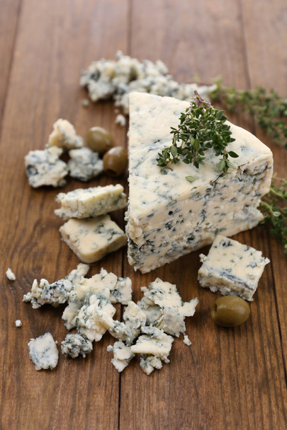 Tasty blue cheese with thyme, on wooden table - Фото, изображение