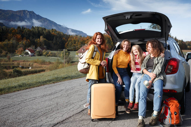 big family trip - happy girls travel by car. mamma with daughters sitting in the boo - 写真・画像