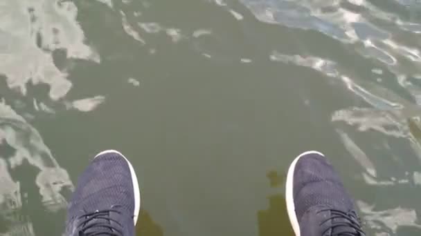 turista lábak a víz felett - Felvétel, videó