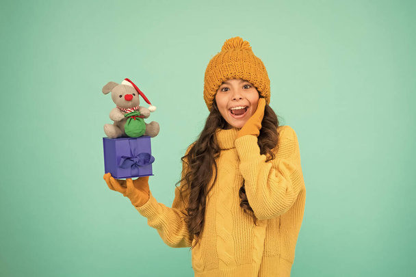 Appease with gift. Shopping tips. Rat symbol of year. Happy girl hold mouse toy and wrapped gift box. Kid knitted sweater and hat play plush toy. Shop for kids. Happy 2020 year. Gift for good luck - 写真・画像