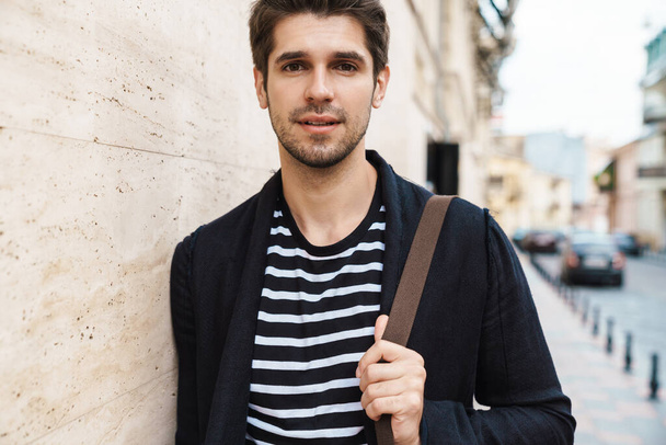 Photo of a young handsome young business man walking by street outdoors - Foto, Imagem