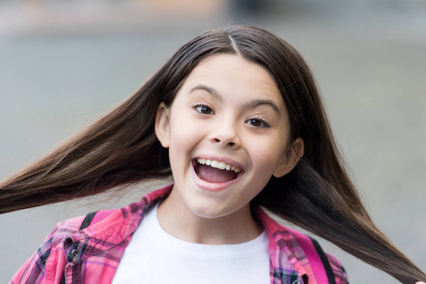 Because we obsess about your hair. Happy girl hold silky long hair outdoors. Beauty look of little child. Hair salon. Shampoo and conditioner. Expert care for every haircare need - 写真・画像