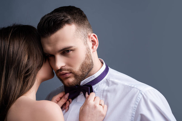Woman holds mans bowtie, bow tie. Sexy couple in love. Sensual lovers undressed. Girlfriend and boyfriend sensual hugging. Boy girl romantic embracing. Tender hug. Naked passion body. - Valokuva, kuva