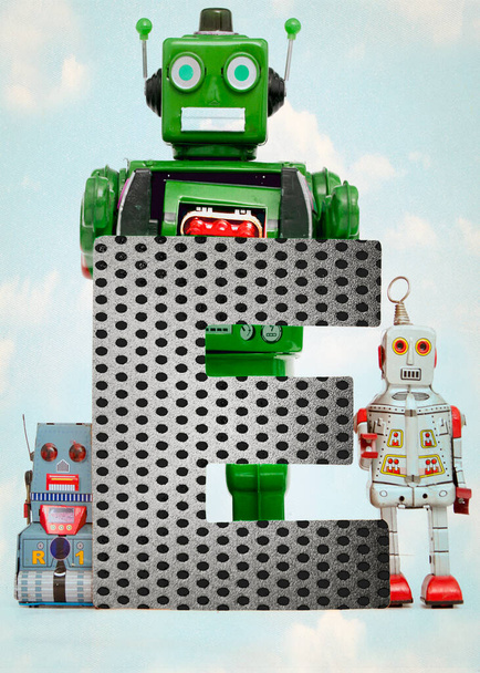 Retro-Roboterspielzeug hält einen großen Buchstaben F hoch - Foto, Bild