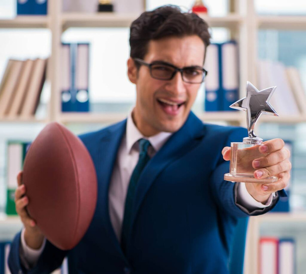 Businessman with american football in office - Photo, Image