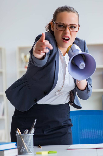 Злая деловая женщина кричит с громкоговорителем в офисе - Фото, изображение