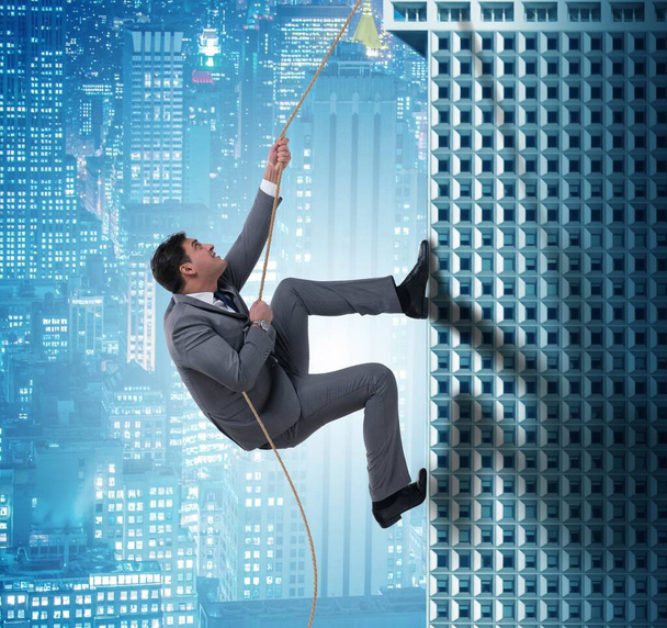The businessman climbing skyscraper in challenge concept - Photo, Image