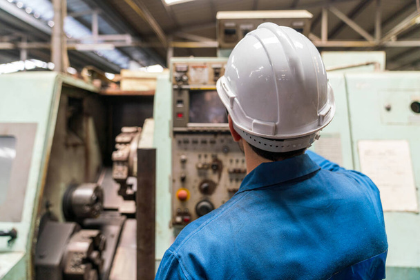 Technicians work at industrial machines in large factories. - Foto, afbeelding