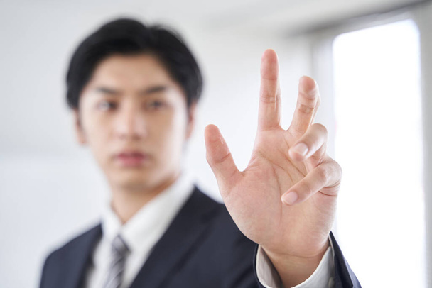 Японский бизнесмен нажимает кнопку в конференц-зале для синтеза текста - Фото, изображение