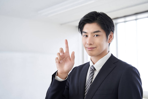Японский бизнесмен указывает в конференц-зале для синтеза текста - Фото, изображение