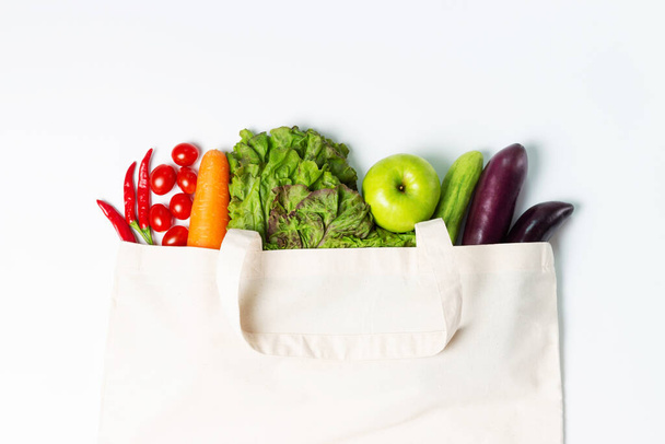 Colorful vegetables and fruits in a linen bag on white background - Φωτογραφία, εικόνα