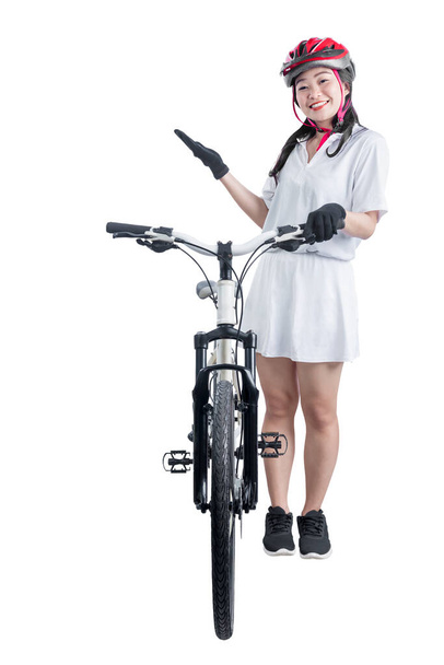 Asian woman with a bicycle helmet standing beside her bicycle isolated over white background - Photo, image