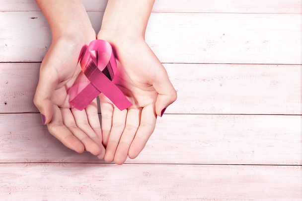 Human hands showing pink awareness ribbon. Breast cancer awareness - Photo, Image