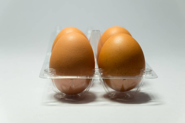 huevo de gallina fresco en envases de plástico sobre fondo blanco. - Foto, imagen