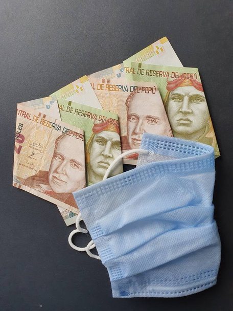 niebieska jednorazowa maska i peruwiańskie banknoty o różnych nominałach - Zdjęcie, obraz