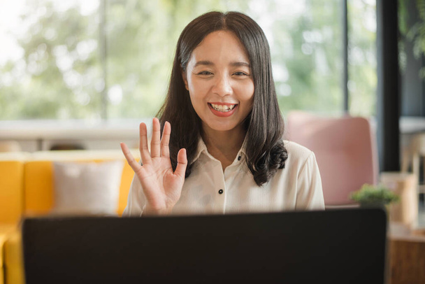 азіатська жінка посміхається на відео дзвінок з друзями вдома
. - Фото, зображення