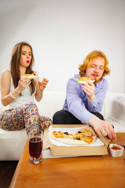 Man and woman spending time together. Couple or friends eating delicious cheesy pizza. - Zdjęcie, obraz