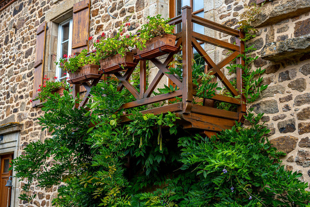 Casa de piedra de arquitectura tradicional en pueblo francés. Ventana balcón jardín decorado con una mezcla de muchas plantas y flores. - Foto, imagen