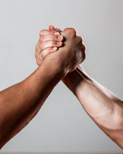 Rywalizacja, zbliżenie męskich zapasów na rękę. Muskularni mężczyźni mierzą siły, ręce. Walka na rękę, rywalizacja. Ręce lub ramiona człowieka. Muskularna ręka. Zapasy na rękę. Dwóch mężczyzn walczy na rękę. - Zdjęcie, obraz