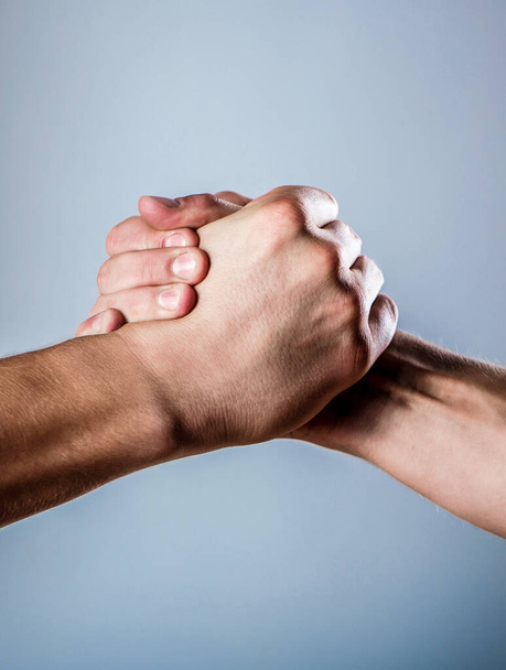 Handshake, arms. Friendly handshake, friends greeting. Male hand united in handshake. Two hands, isolated arm, helping hand of a friend - Фото, изображение