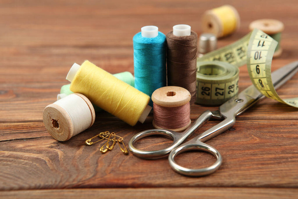 different sewing accessories on the table. Threads, needles, pins, fabric and sewing scissors close up - Foto, Imagen