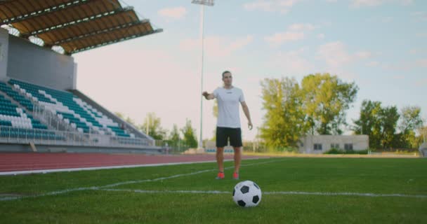 Slow-Mo: Fußballer, der einen Ball kickt. Flachschuss des Fußballers. Fußballprofi kurz davor, Fußball während eines Fußballspiels zu kicken - Filmmaterial, Video