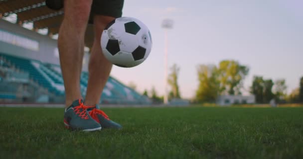 Professionele voetballer is jongleren met een bal. socker een speler in een wit voetbaluniform in het stadion - Video