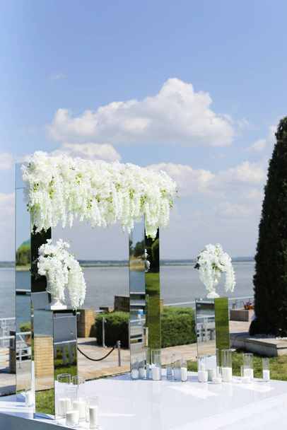 背景に湖と白い美しい結婚式の祭壇. - 写真・画像