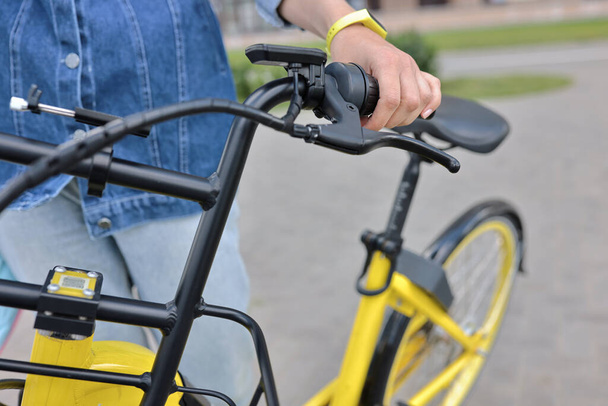 Radfahrer hält gelbes Fahrrad hinter Lenkrad fest - Foto, Bild