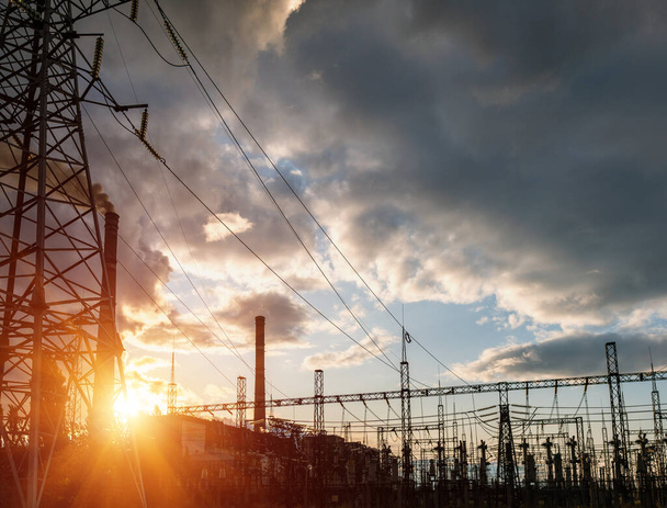 High voltage power lines at sunset. Thermal power plant. High-voltage transformer substation. - Photo, Image