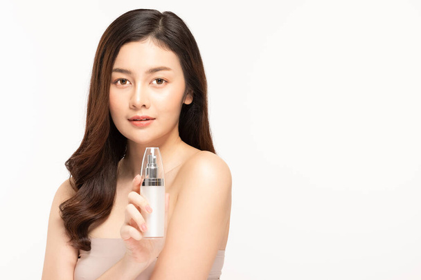Bellezza donna asiatica tenere bottiglia crema cosmetica lozione e allegro. - Foto, immagini
