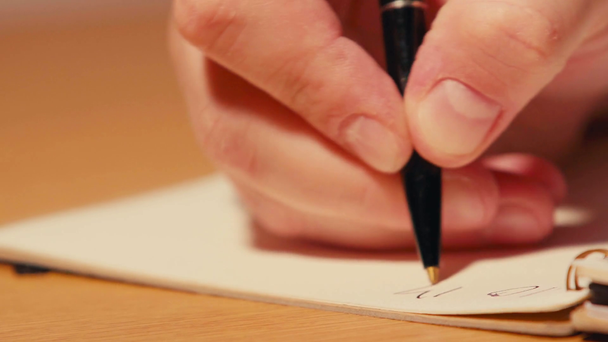 Close up view of man writing on spiral notebook - Footage, Video