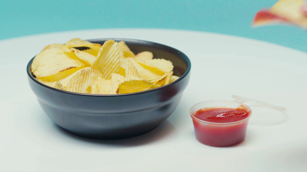 Селективный фокус человека, погружающего чипсы в кетчуп - Кадры, видео