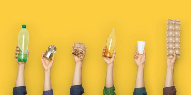 Hands hold trash on a yellow background. The concept of separate trash, stop plastic, recycling - Foto, imagen